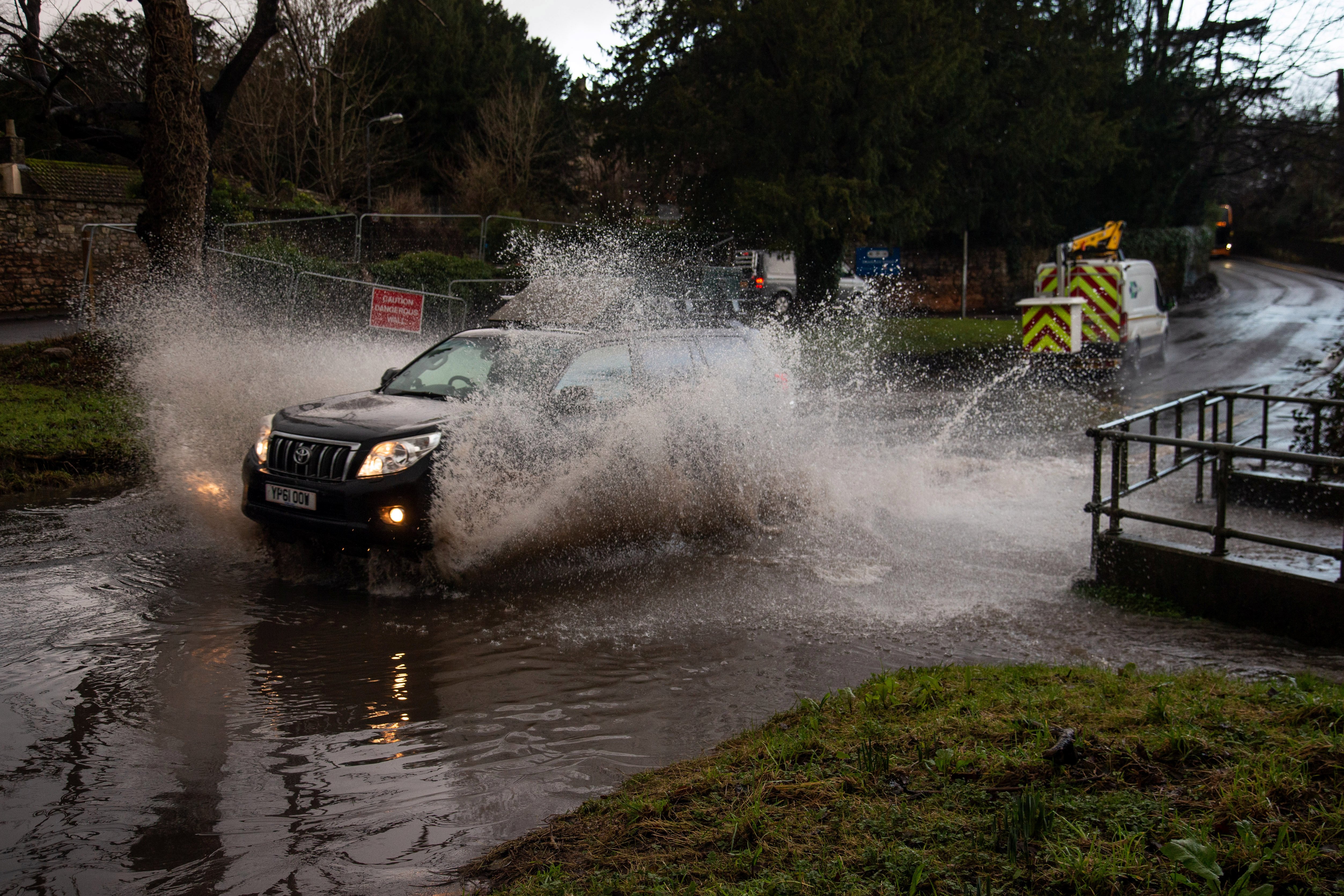 Cars pass through a flooded Hazel Brook in Bristol caused by Storm Christoph