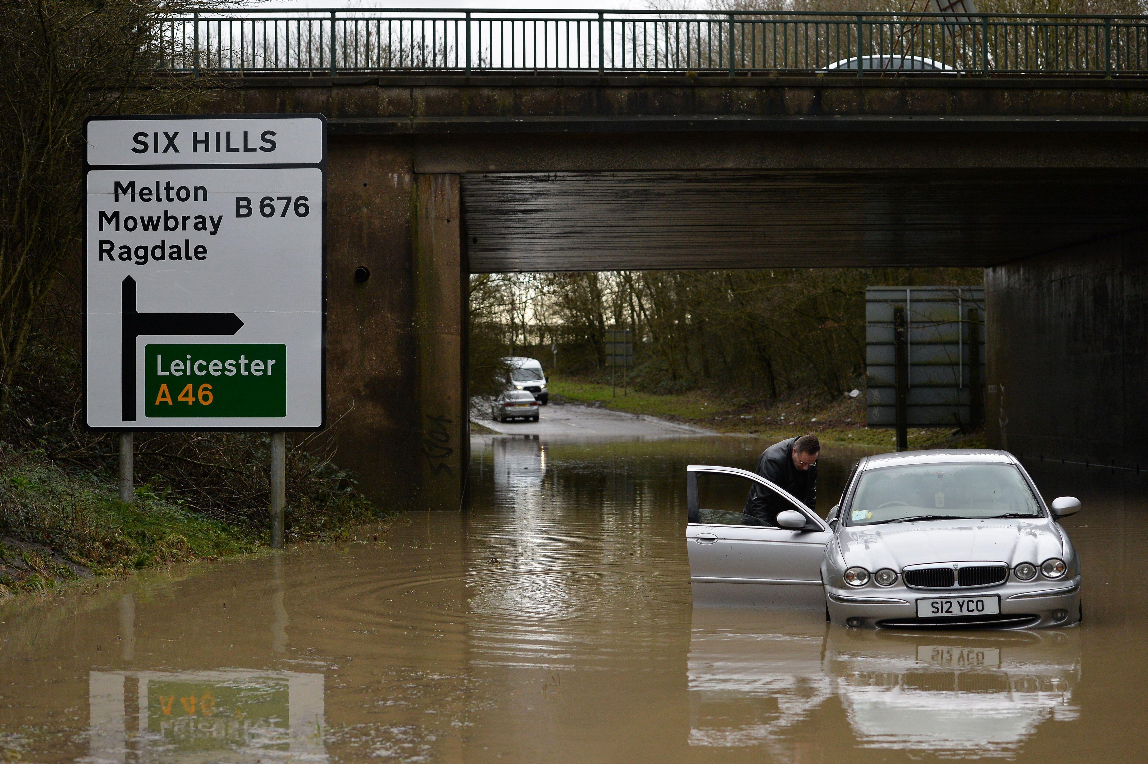 A Leicester local is forced to push his car out of floodwater underneath the A46 after getting stuck