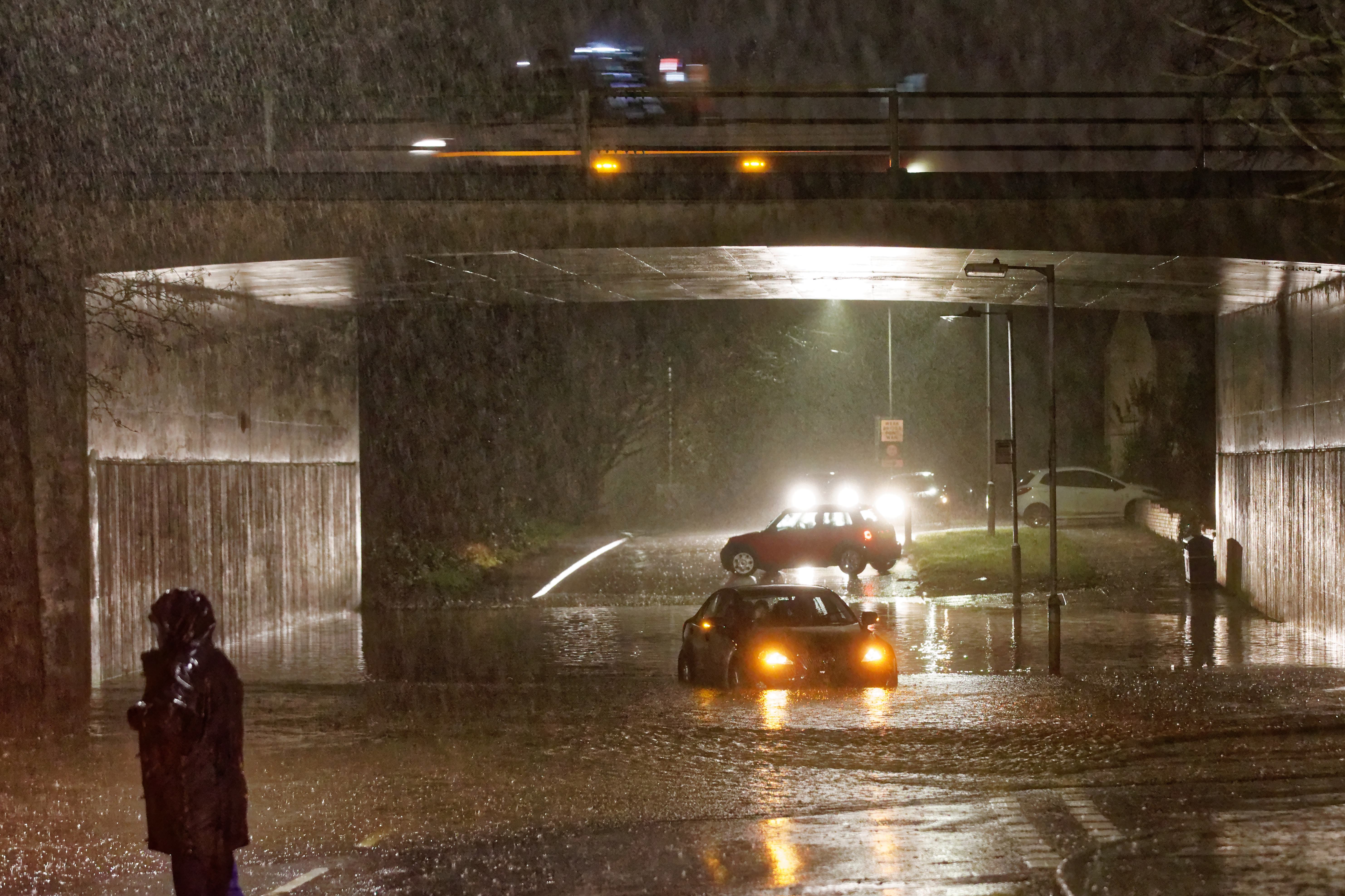 A driver is trapped in their Lexus car while attempting to drive through Walters Road which got flooded under the M4 motorway in Swansea, Wales