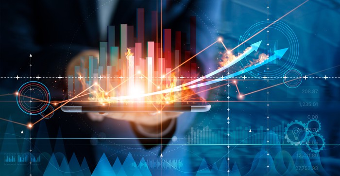Person holding tablet with bar chart and arrows above it