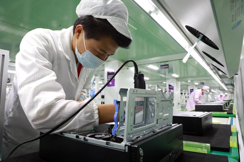 A line operator assembles an electronic device