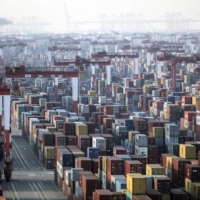 Shipping containers next to gantry cranes at the Yangshan Deepwater Port in Shanghai on Monday | BLOOMBERG