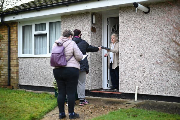 Volunteers delivering testing kits in Woking, England, on Tuesday. The authorities are hoping that screening will help to track down a coronavirus variant, first found in South Africa, that has also surfaced in areas of Britain.