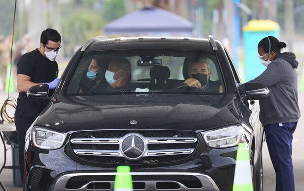 Health care workers at a drive-through vaccination site in Miami last month.