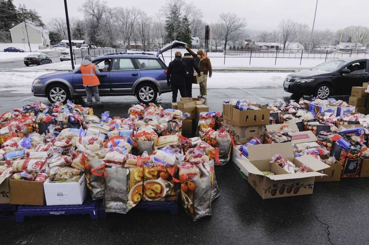 A mass food distribution takes place Friday, Feb. 26, 2021 at Macedonia Baptist Church at 26 Wilson Ave. in Albany. In this photo, volunteers load food bags and boxes into vehicles during a previous mass food distribution put on by Catholic Charities of the Diocese of Albany, and the Regional Food Bank of Northeastern New York on Tuesday, Feb. 16, 2021, at Watervliet High School in Watervliet, N.Y. (Paul Buckowski/Times Union)