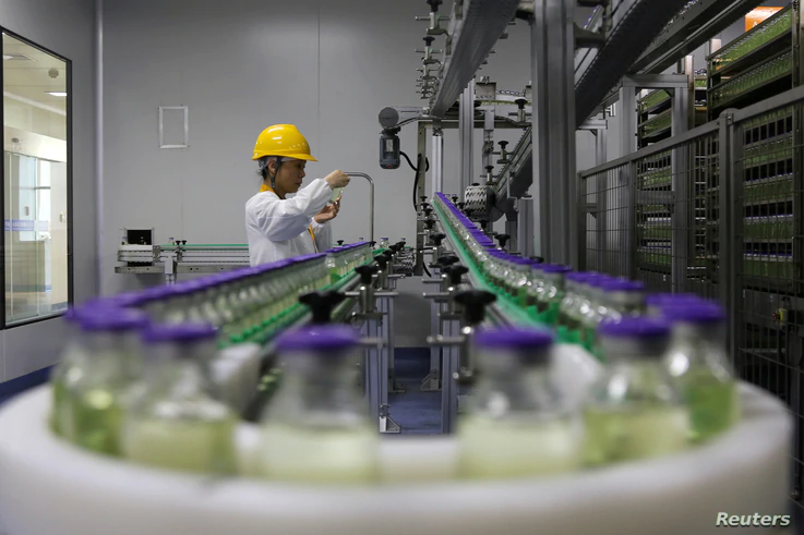 FILE - An employee works on a production line manufacturing drugs at the Yangtze River Pharmaceutical Group in Taizhou, Jiangsu province, China, Sept. 3, 2019.