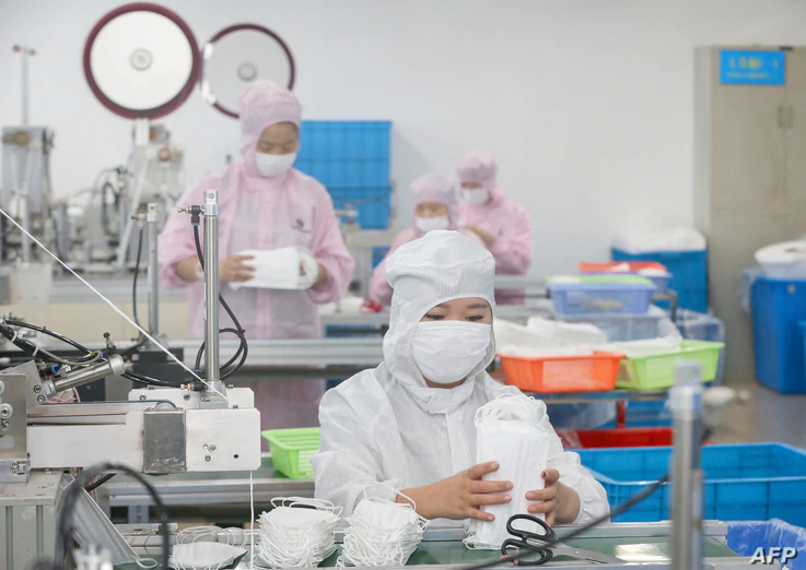 FILE - Workers produce face masks for export, at a factory in Nantong, in China's eastern Jiangsu province, May 14, 2020.