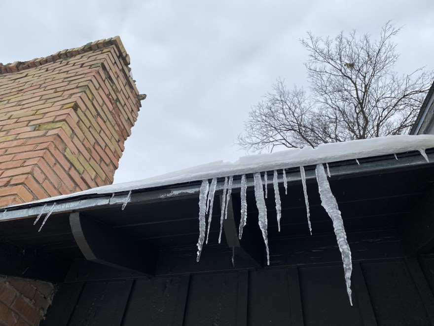 Icicles hanging from the edge of the roof of a home in Dallas.