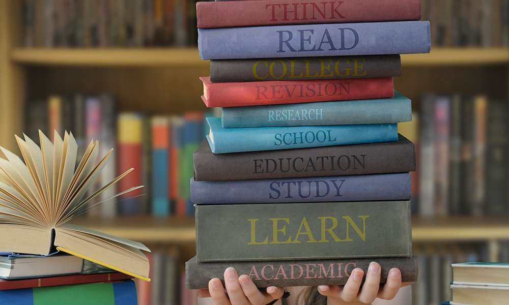 image of student holding stack of books