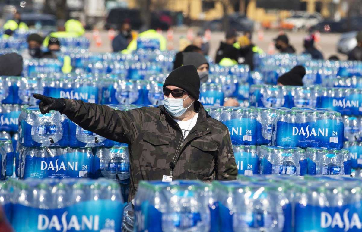 Volunteers help distribute free bottled water Friday at Delmar Stadium. The supplies ran out by 2 p.m.
