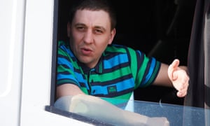 Close up of Mateusz Kozlowski in the white cab of his truck, wearing a striped top