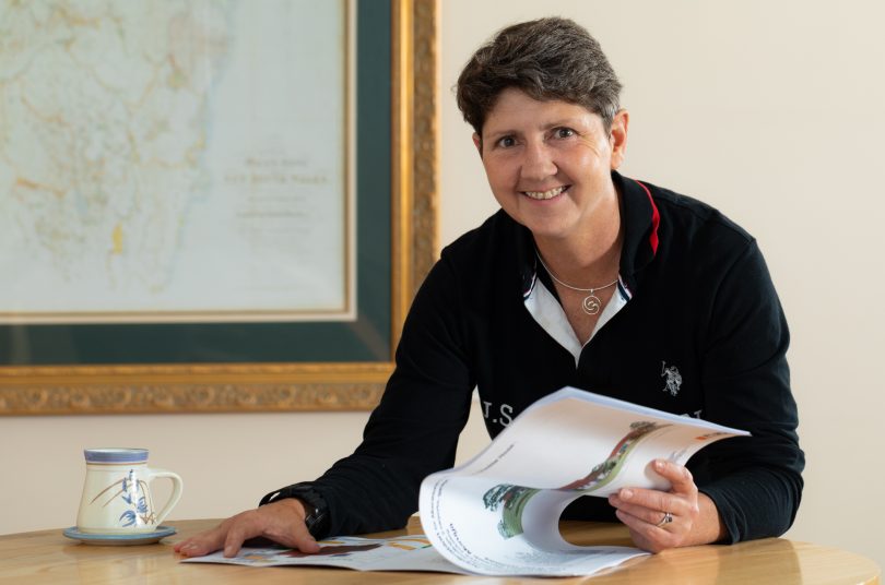 Sue Melotte sitting at table reading development application.