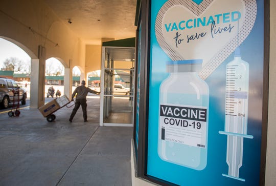 A worker brings supplies on Monday into a defunct Stein Mart store that Augusta University is turning into a COVID-19 vaccination clinic in Augusta, Ga.