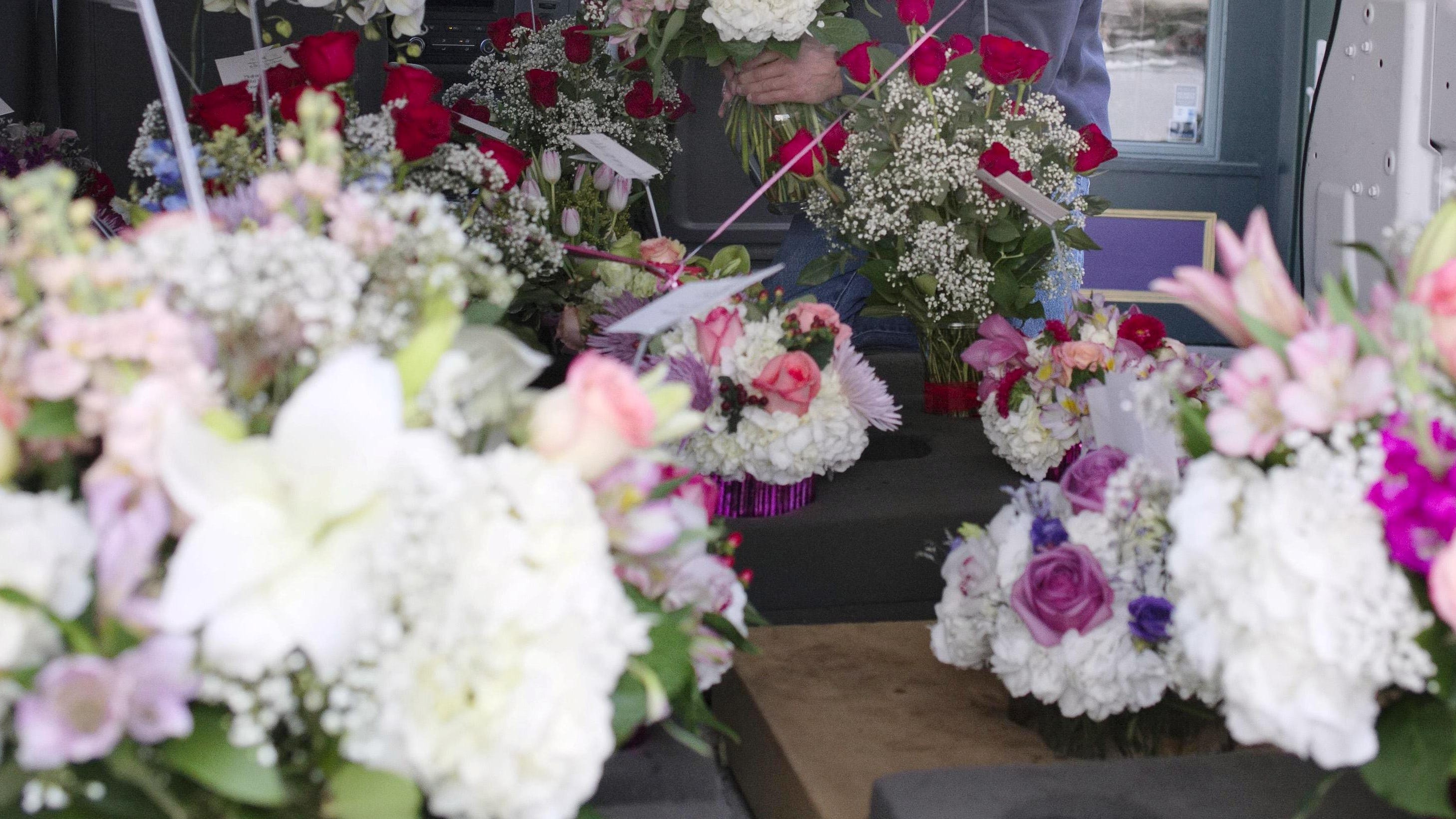 Flowers are lined up in the back of a delivery van waiting to be delivered.