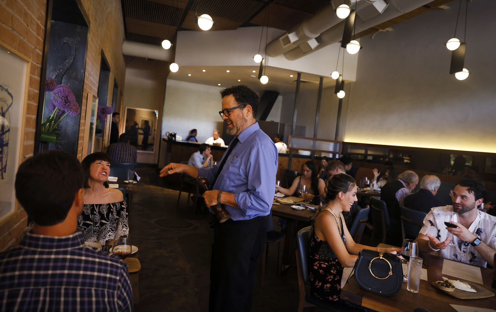 Server David Walsh waits on a table at the nearly full Nonna restaurant in Dallas, Friday evening, July 2, 2021.