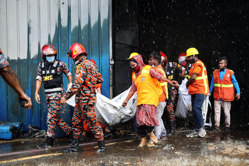 Bodies are being carried from a building by firefighters