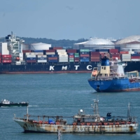 A container vessel makes its way along the Singapore Strait on June 28. | AFP-JIJI