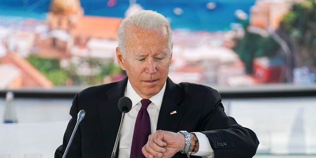U.S. President Joe Biden checks his watch during an event on global supply chain resilience through the coronavirus disease (COVID-19) pandemic and recovery, on the sidelines of the G20 leaders' summit in Rome, Italy October 31, 2021.