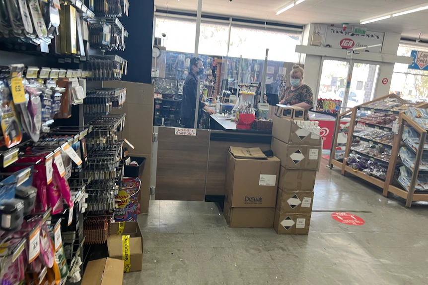 Blurry image inside a supermarket, with customer at check out in background.