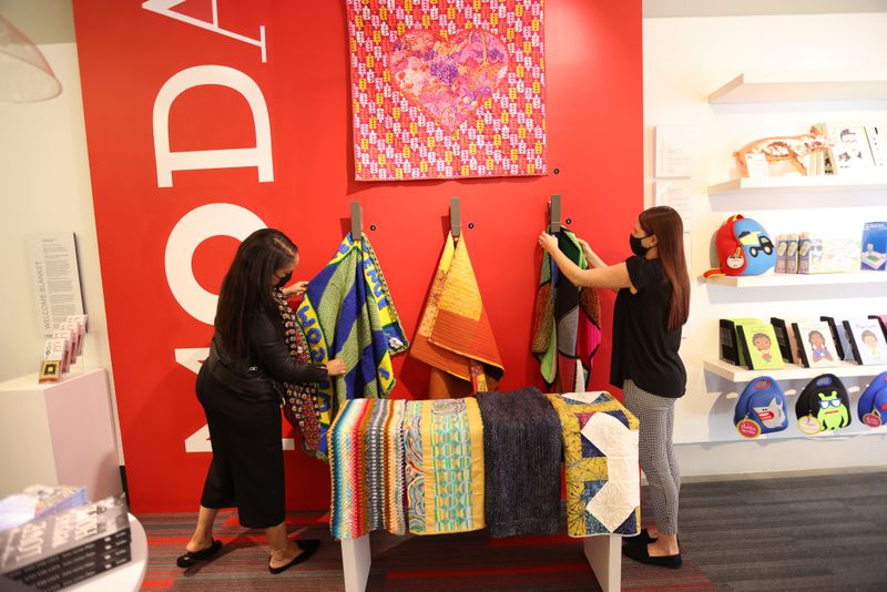 Tiffany Ricks, left, community engagement coordinator, and Miranda Hazelwood, visitor experience manager at Museum of Design Atlanta, organize the blankets that have been donated. The blankets will be on display to the public. Miguel Martinez/for The AJC