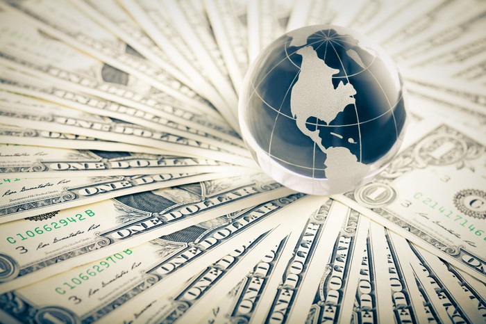 A globe surrounded by U.S. $1 bills.