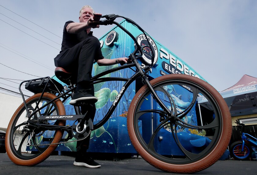 Tom Bock, owner of a Pedego Electric Bikes in Huntington Beach, rides an ebike.