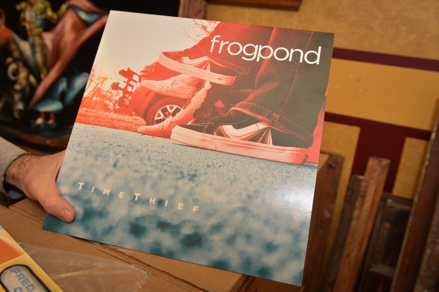 Shawn Saving's hand holding an album sleeve for the band Frogpond.