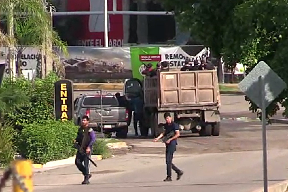 In this AFPTV screen grab armed gunmen are seen in a street of Culiacan, state of Sinaloa, Mexico, on October 17, 2019. - Heavily armed gunmen in four-by-four trucks fought an intense battle against Mexican security forces Thursday in the city of Culiacan, capital of jailed kingpin Joaquin "El Chapo" Guzman's home state of Sinaloa. (Photo by STR / AFP) (Photo by STR/AFP via Getty Images)