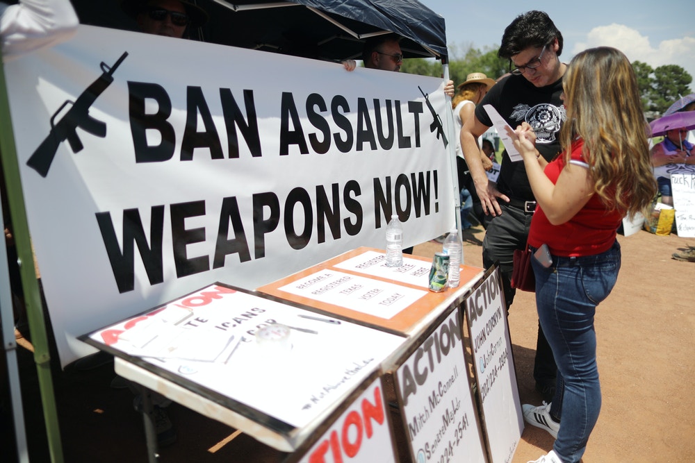EL PASO, TEXAS - AUGUST 07: A 'Ban Assault Weapons Now' sign is displayed near a voter registration table at a protest against President Trump's visit, following a mass shooting which left at least 22 people dead, on August 7, 2019 in El Paso, Texas. Protestors also called for gun control and denounced white supremacy. A 21-year-old white male suspect remains in custody in El Paso which sits along the U.S.-Mexico border. (Photo by Mario Tama/Getty Images)