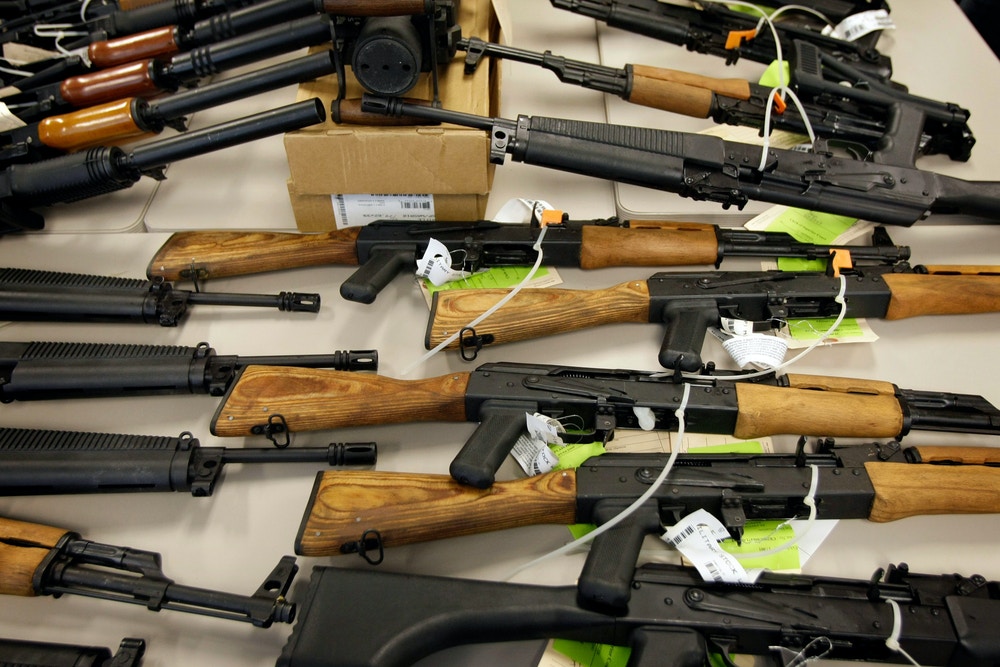FILE - In this Jan. 25, 2011, file photo, a cache of seized weapons that were to be smuggled into Mexico is displayed in Phoenix. Among the thousands of immigrants who have been coming across the U.S.-Mexico border in recent months, many are seeking to escape gang and drug violence raging in their homelands. The weapon of choice used to intimidate them is often an American-made gun. Gun-control advocates and some experts say the very violence that immigrants are fleeing is carried out by American guns that are smuggled over the border. (AP Photo/Matt York, File)