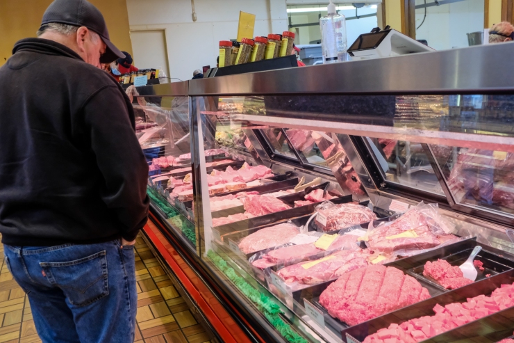 A customer looks at meat displayed behind a case at Schmidt's Meat Market.