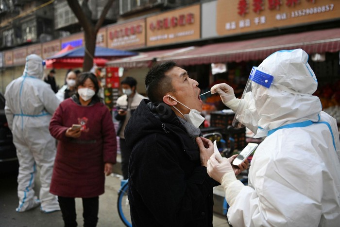 A medical worker collects a swab sample from a civilian at a mobile testing site in Xi’an, in northwestern China’s Shaanxi Province