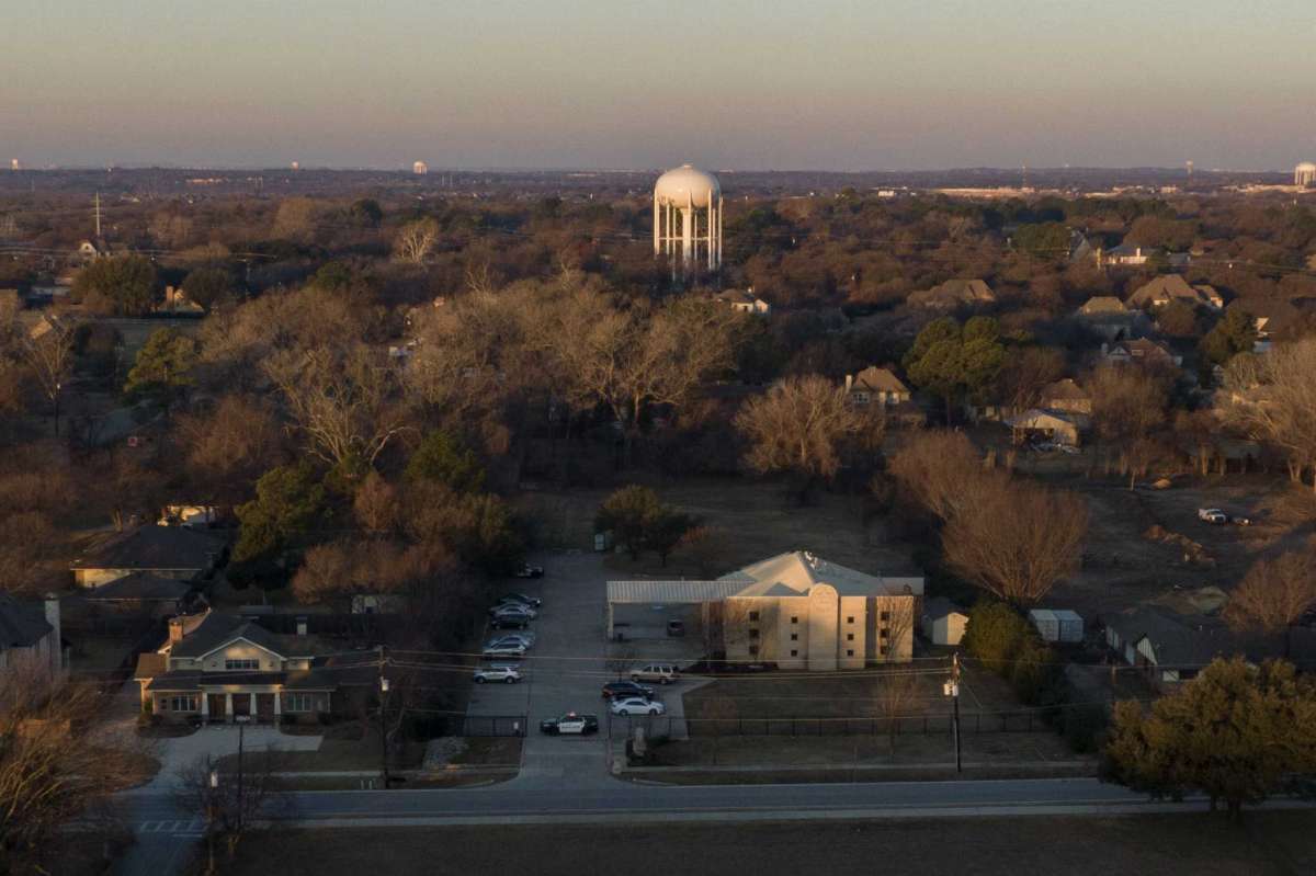 FILE - Police vehicles are parked in front of Congregation Beth Israel synagogue, Sunday, Jan. 16, 2022, in Colleyville, Texas. A British man who held four people hostage in a Texas synagogue ranted against Jews and American wars in countries like Afghanistan as his brother pleaded with him to give up and free the captives, a recording of the conversation showed.