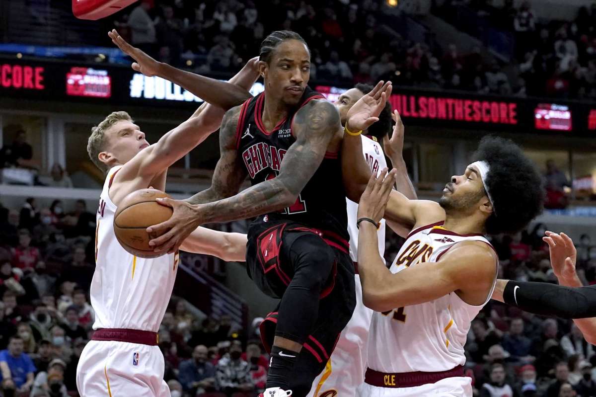 Chicago Bulls' DeMar DeRozan, center, looks to pass under pressure from Cleveland Cavaliers' Lauri Markkanen, left, Evan Mobley, behind, and Jarrett Allen during the second half of an NBA basketball game Wednesday, Jan. 19, 2022, in Chicago. The Bulls won 117-104.