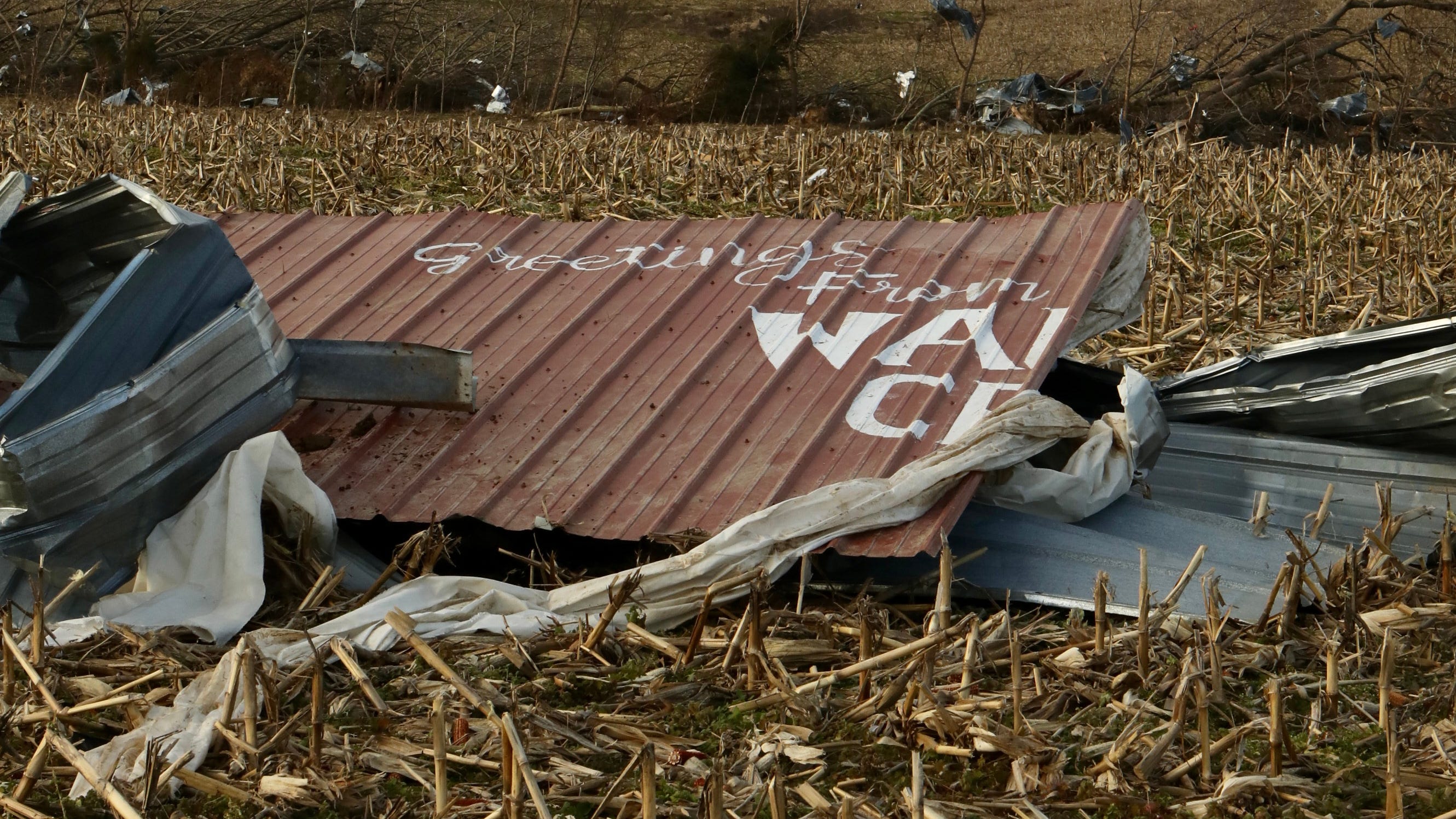 Half of a sign that reads, "Greetings from Walton Creek" lies in a field near Centertown, Ky., after a tornado passed through in early December. The other half of the sign was found a mile away. The message adorned a garage owned by Ben Ashby, whose insurance will only partially cover $128,000 in damage to several buildings on his property.