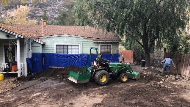 After a wall of mud hit their home in Silverado, Calif., on Dec. 14, 2021, the Shimbo family, their neighbors and volunteers have spent weeks reinforcing the house and clearing the mud.