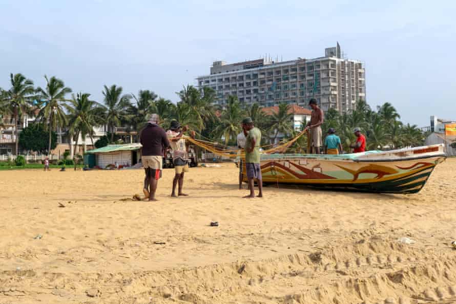 Fishermen with a boat on Negombo beach