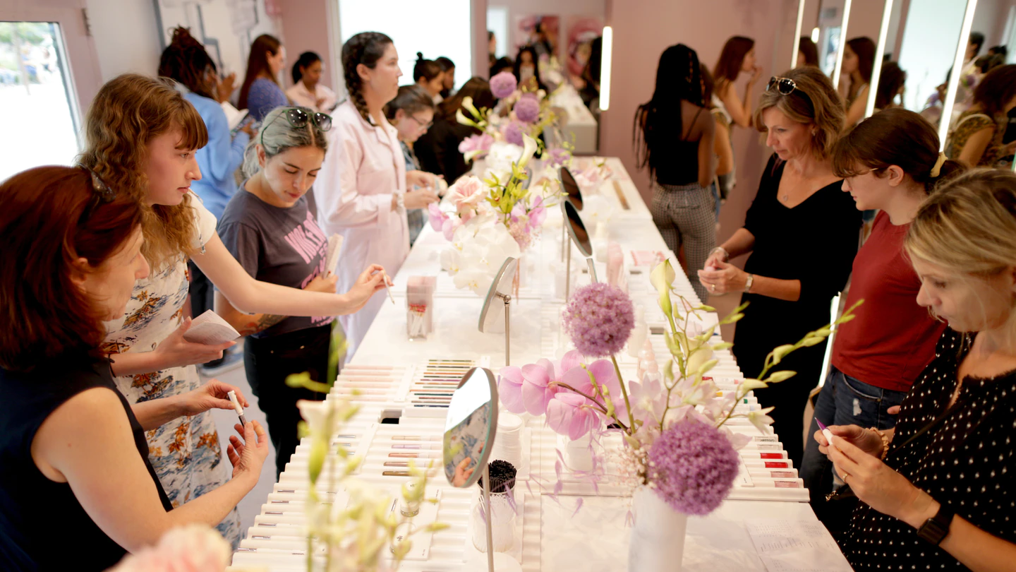 Customers try out products at a Glossier pop-up.