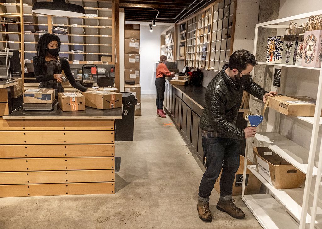 Worker Ophelia Rauch, left, scans an Amazon labeled box as a customer packs an outgoing package at Sip and Ship in Seattle on Jan. 4.