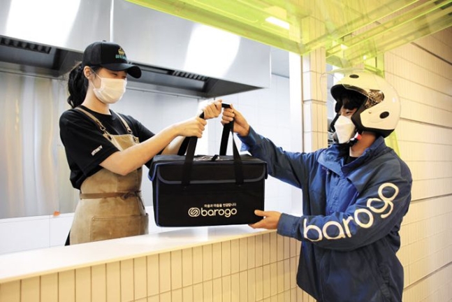 This undated photo, provided by Barogo, shows a deliveryman carrying a package at a restaurant for delivery service.