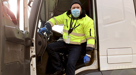 young transporter on the truck with face mask and protective gloves for Coronavirus