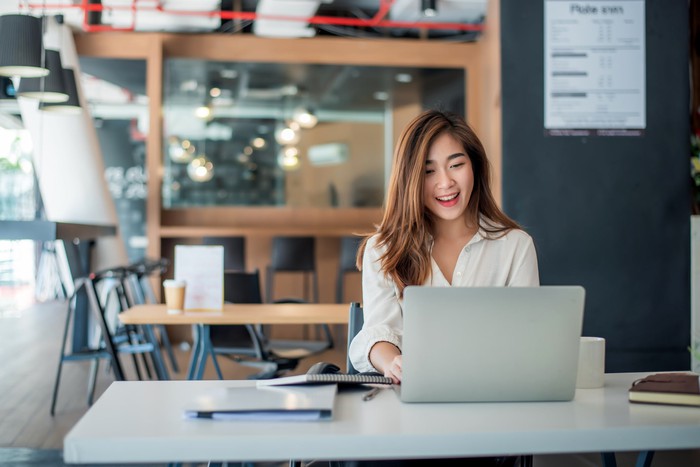 Smiling person looking at a computer.
