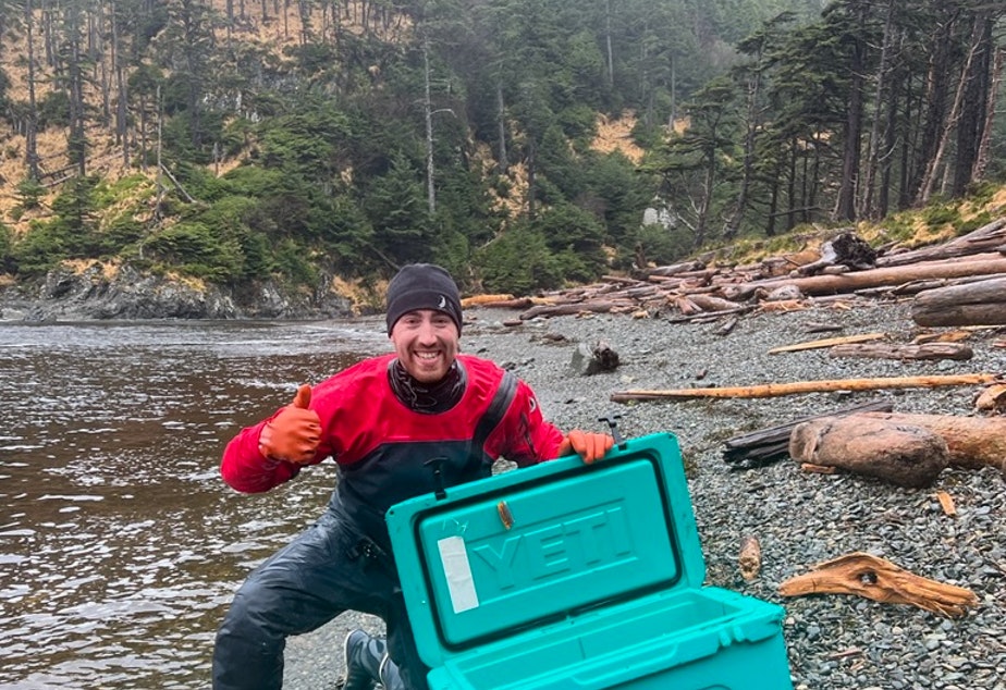 caption: Gwaii Haanas Park Reserve and Haida Heritage Site scientist Geoff Martynuik celebrates after finding an expensive cooler washed up on the west coast of Haida Gwaii on Oct. 30, 2021. 