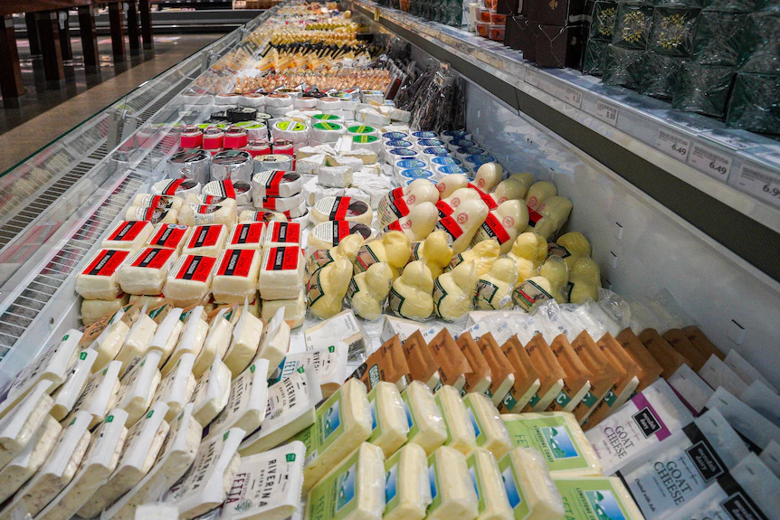A picture of cheese in a supermarket.