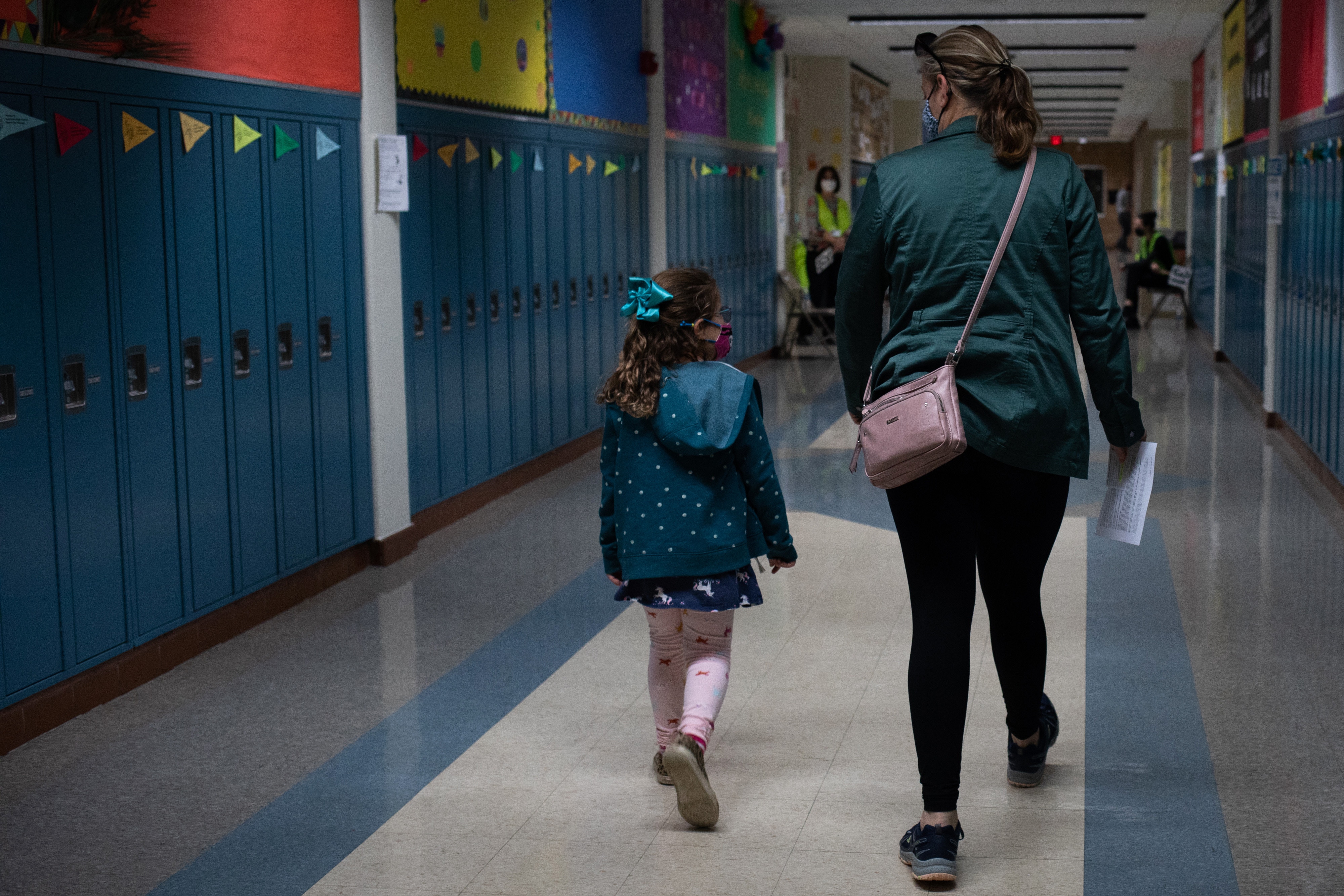 A child walks with her mother to the observation area after receiving a dose of the Pfizer-BioNTech Covid-19 vaccine at a clinic at Hazel Park High School in Hazel Park, Michigan, U.S., on Monday, Nov. 8, 2021. About 28 million kids became eligible for Pfizer Inc. and BioNTech SEs vaccine following Food and Drug Administration authorization Oct. 29 and the CDC signoff on earlier this week. Photographer: Emily Elconin/Bloomberg via Getty Images