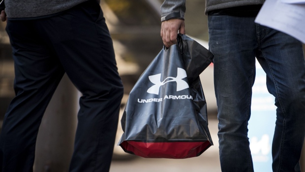 A pedestrian carries an Under Armour Inc. shopping bag in downtown Chicago, Illinois, U.S., on Monday, Oct. 16, 2017. Under Armour must improve and expand its footwear business to counter constant challenges to its apparel market share from new entrants, most recently Amazon.com. Photographer: Christopher Dilts/Bloomberg, Bloomberg A pedestrian carries an Under Armour Inc. shopping bag in downtown Chicago, Illinois, U.S., on Monday, Oct. 16, 2017. Under Armour must improve and expand its footwear business to counter constant challenges to its apparel market share from new entrants, most recently Amazon.com. Photographer: Christopher Dilts/Bloomberg