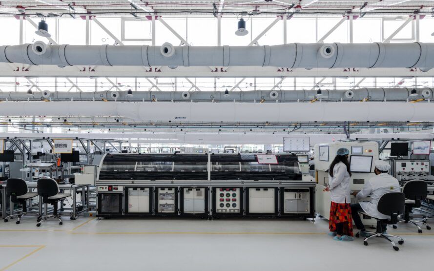A white hallway with window cutouts and a machinery in the center