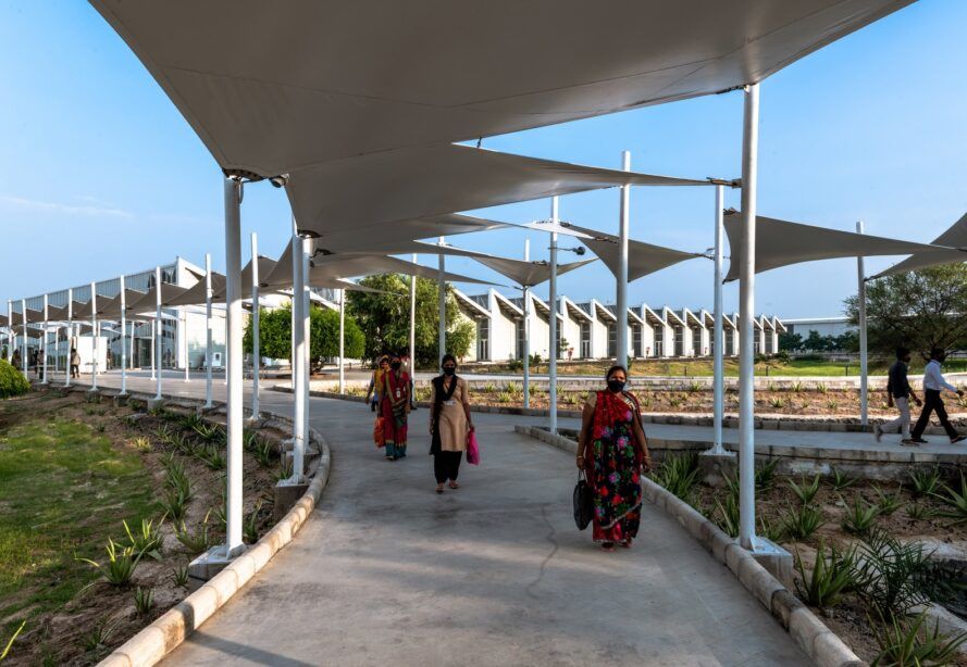 An outdoor hallway with people walking underneath the awning