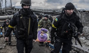 Ukraine’s territorial defence force help evacuate an elderly woman from Irpin, near Kyiv, yesterday.