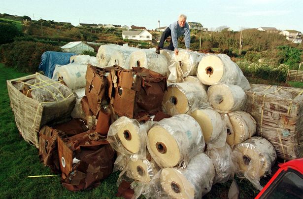 Salvage diver James Heslin on top of some of the rolls of polyester plastic retrieved fro the wreck of the Cita